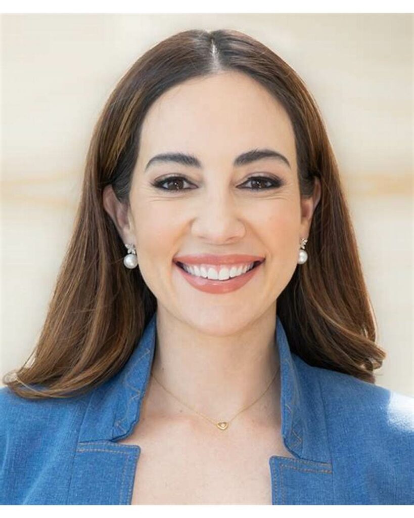 Mariana Atencio close-up headshot in blue blazer with pearl earrings